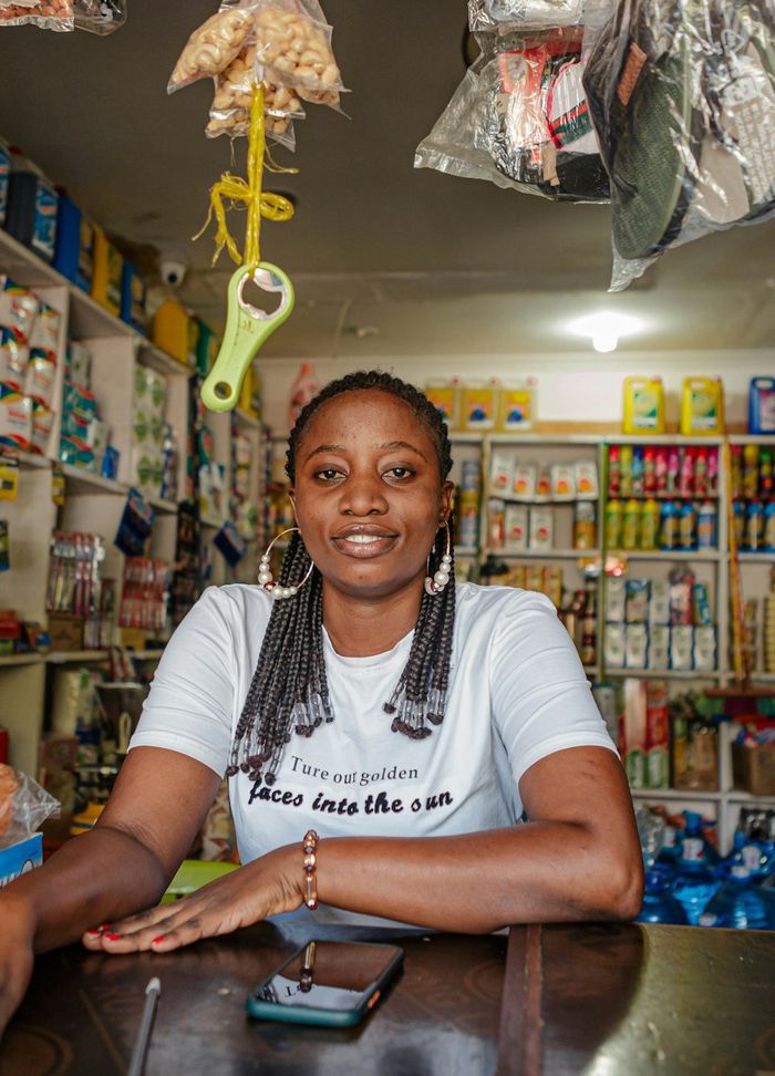 A shop owner sitting at the counter of her store