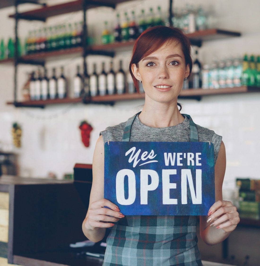 A smiling New Zealand small business owner welcoming customers to her shop
