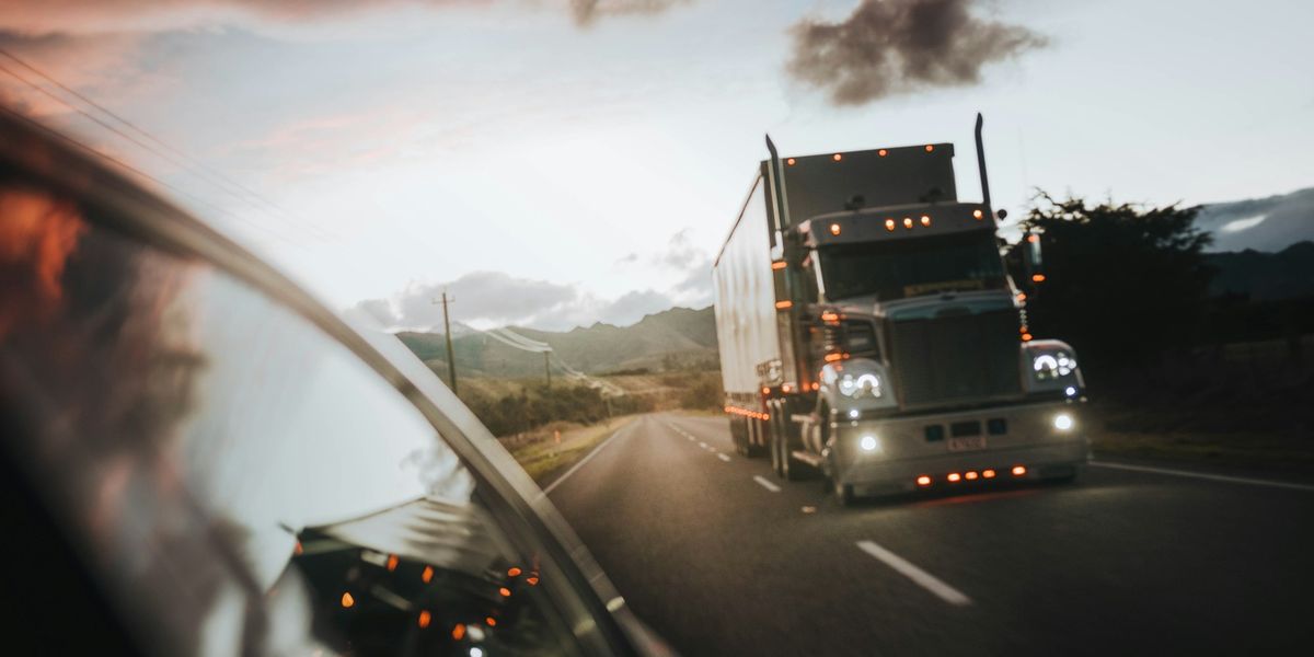 A truck driving along a New Zealand highway in evening light