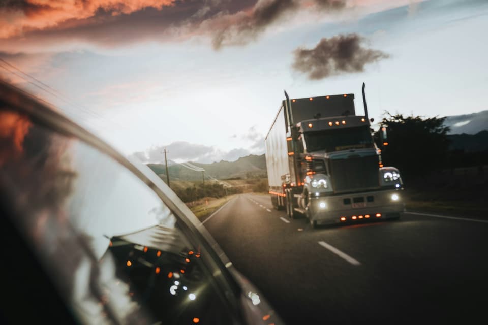 A truck driving along a New Zealand highway in evening light